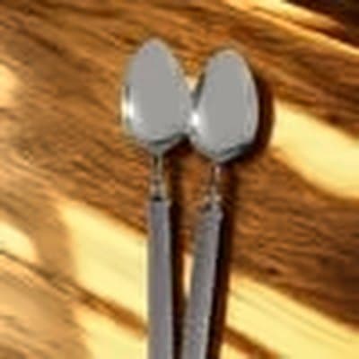 Two steel spoons in sunlight